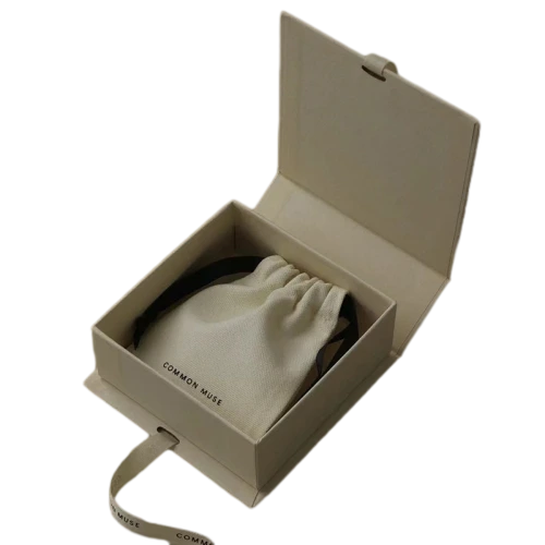 This minimalist flip top magnetic rigid gift box comes in multiple textured exterior colour selections including cream white, deep black and mustard yellow. It is matched with detachable satin ribbon printed with warm wish text for elegant wrapping decoration. The sturdy thick cardboard maintains sharp box shape, and the built in magnet enables smooth opening and tight closure. The interior can hold custom branded fabric drawstring pouches for jewellery, trinkets and cosmetics. Custom surface texture, personalized ribbon printing and bespoke sizing service are supported, well suited for holiday gifts, party favours and brand retail bulk order wholesale.