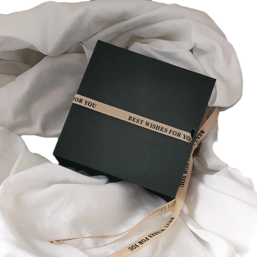 This minimalist flip top magnetic rigid gift box comes in multiple textured exterior colour selections including cream white, deep black and mustard yellow. It is matched with detachable satin ribbon printed with warm wish text for elegant wrapping decoration. The sturdy thick cardboard maintains sharp box shape, and the built in magnet enables smooth opening and tight closure. The interior can hold custom branded fabric drawstring pouches for jewellery, trinkets and cosmetics. Custom surface texture, personalized ribbon printing and bespoke sizing service are supported, well suited for holiday gifts, party favours and brand retail bulk order wholesale.