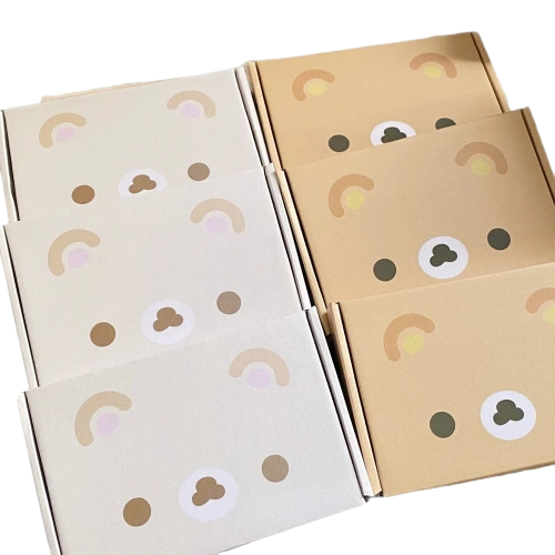 These lovely cartoon beartheme corrugated mailer boxes adopt soft beige and offwhite base matched with delicate rainbow and bearfaced prints. Flat unassembled cardboard sheets help cut down storage space and shipping expense. Some styles are designed with reserved air holes for breathable storage. The durable corrugated material delivers fine shockproof performance in transit. Custommade surface pattern and brand logo printing are supported, well suited for baby accessories small presents and dailyuse commodity wholesale packaging.