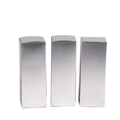 These premium metallic silver cardboard cartons come in multiple tall rectangular specifications and can be stored as flat unfolded sheets for convenient transportation. The glossy mirror like silver surface delivers a high end metallic texture. Made of tough fold able cardstock with stable auto lock bottom structure, these blank boxes are well suited for lipstick, perfume bottles and assorted cosmetic supplies. Custom sized measurements, surface printing and special surface treatments are supported, perfect for luxury commodity packaging and large batch wholesale supply.