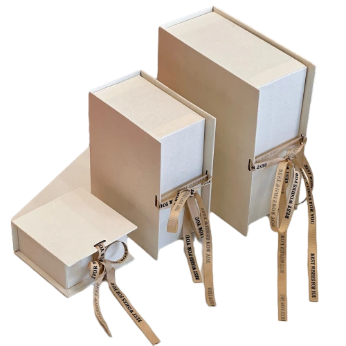 These minimalist sliding drawer custom rigid gift boxes are made of delicate textured off white paper and available in square short rectangle and tall rectangle dimensions. Each box comes with detachable beige satin ribbon printed with BEST WISHES FOR YOU which can be tied into elegant bows for decoration. The durable thick cardboard structure resists bending and abrasion. Custom ribbon text outer box logo printing and bespoke sizes are supported well suited for jewellery perfume small sized cosmetics hand made presents and holiday gift set wholesale orders.