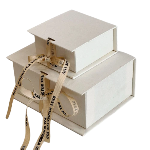 These minimalist sliding drawer custom rigid gift boxes are made of delicate textured off white paper and available in square short rectangle and tall rectangle dimensions. Each box comes with detachable beige satin ribbon printed with BEST WISHES FOR YOU which can be tied into elegant bows for decoration. The durable thick cardboard structure resists bending and abrasion. Custom ribbon text outer box logo printing and bespoke sizes are supported well suited for jewellery perfume small sized cosmetics hand made presents and holiday gift set wholesale orders.