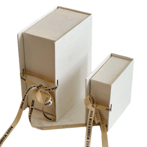 These minimalist sliding drawer custom rigid gift boxes are made of delicate textured off white paper and available in square short rectangle and tall rectangle dimensions. Each box comes with detachable beige satin ribbon printed with BEST WISHES FOR YOU which can be tied into elegant bows for decoration. The durable thick cardboard structure resists bending and abrasion. Custom ribbon text outer box logo printing and bespoke sizes are supported well suited for jewellery perfume small sized cosmetics hand made presents and holiday gift set wholesale orders.