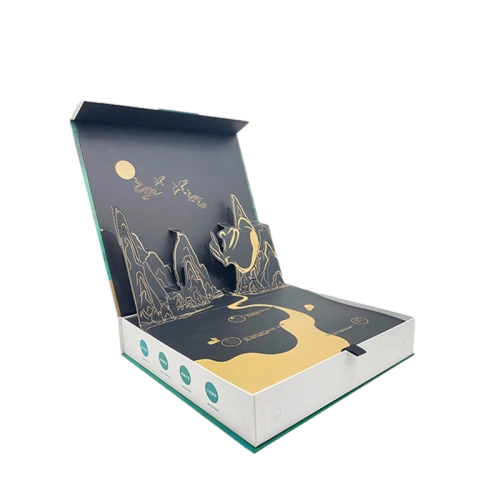 This premium custom rigid box is constructed from heavy duty hardboard with clean white outer casing and green edge trim. A stunning three dimensional popup mountain landscape with gold foil printing appears once the lid is opened creating an impressive unboxing experience. Custom printed patterns text and circular label marks can be added on the inner base surface. Hidden magnetic closure keeps the box tightly sealed after closing. This elegant gift box works perfectly for tea sets premium food gifts holiday souvenirs and highend promotional presents. Custom popup shapes foil colors and outer artwork are all available to match your brand theme. Its tough rigid frame provides excellent protection for contents during shipment and luxury retail display. It is an outstanding upscale packaging solution for brand merchants and large volume wholesale orders.