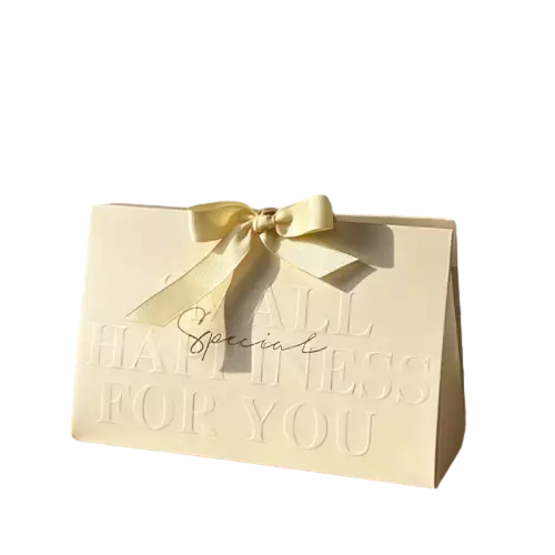 These warm delicate gift paper bags are made of premium cream yellow matte paper with elegant embossed greeting letters on the front surface. A soft satin ribbon bow is tied on the top to enhance the romantic and festive atmosphere. The special triangle foldover structure provides enough inner space for chocolate candy soap and other small party favors. Thick sturdy paper keeps the bag well shaped without easy bending. You can customize embossed words printed logo and ribbon color to match your brand or event theme. These beautiful gift bags are ideal choices for wedding favors birthday treats baby shower gifts and holiday giveaways. Wholesale bulk orders are welcomed.