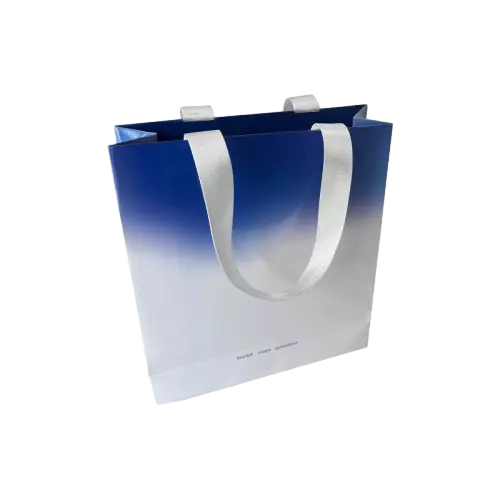 These stylish special craft paper bags adopt fashionable blue to white gradient printing design for a clean modern visual effect. Durable wide white fabric ribbon handles offer comfortable grip and excellent weight bearing capacity. The upright vertical structure provides plenty of inner room for cosmetics clothes and other retail goods. Thick coated paper maintains firm shape and smooth surface for longterm use. You can add custom printed logo brand slogan and text information on the bag exterior. These minimalist gradient paper bags are well suited for brand retail stores cosmetic shops and daily gift packaging. Wholesale bulk orders are welcomed.