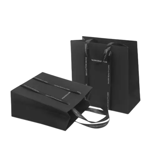 These high end black gift paper bags are produced from thick matte black paper with an elegant low gloss finish. Premium satin ribbon handles can be printed with your unique brand text to strengthen brand recognition. Two common sizes are available to pack cosmetics skincare products jewelry and other luxury goods. Heavy duty paper material provides excellent rigidity so the bags can stand firmly without collapsing. The smooth surface supports various custom printing options including logo brand slogan and decorative patterns. These stylish black tote bags work perfectly for beauty shops fashion boutiques and premium gift packaging. Wholesale bulk orders are welcomed.
