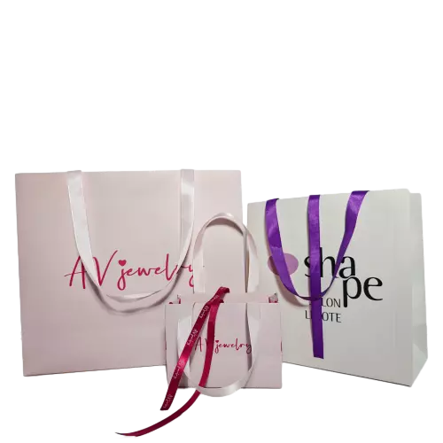 These custom branded paper gift bags are made of high quality thick white paper with smooth matte surface. You can select different colors of satin ribbon handles and print exclusive brand text on both the bag surface and ribbon straps. Multiple sizes are offered to meet packaging requirements for jewelry accessories cosmetics and other small luxury items. Sturdy paper structure keeps each tote bag standing upright steadily. Full custom printing service is available for logo brand slogan and unique artwork. These elegant branded paper bags are perfect packaging choices for jewelry shops beauty boutiques and retail brand promotion. Wholesale bulk orders are welcomed.