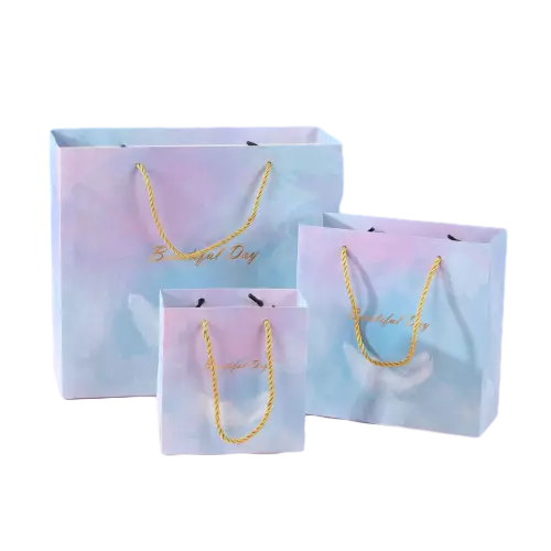 These dreamy gradient gift paper bags are made of high quality thick paper printed with soft pastel watercolor tie dye patterns. Bright golden twisted paper rope handles offer comfortable carrying experience and strong load bearing capacity. Three different sizes are available to meet various gift packaging needs for birthday parties wedding favors holiday surprises and retail goods. The elegant hot stamped golden text adds warm festive atmosphere. You can replace the original words with custom printed logo brand slogan and exclusive artwork. These romantic gradient tote bags are wonderful packaging choices for gift shops party supplies stores and festive occasion delivery. Wholesale bulk orders are welcomed.