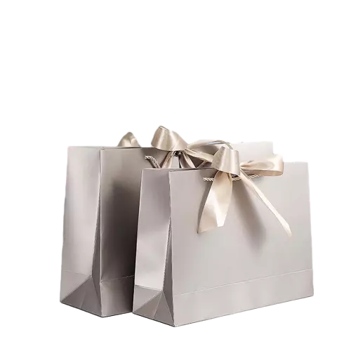 These elegant luxury paper gift bags are produced with thick premium paper finished with soft champagne silver matte surface. Delicate satin ribbon tied into beautiful bow brings romantic upscale appearance. The inner twisted paper rope ensures strong load bearing capacity for daily carrying. Blank smooth outer surface supports full custom printing of logo brand slogan and decorative patterns. This stylish bag works perfectly for jewelry cosmetics wedding gifts birthday surprises and high end retail products. These premium tote bags are wonderful packaging options for luxury boutiques jewelry shops and festive gift giving. Wholesale bulk orders are welcomed.