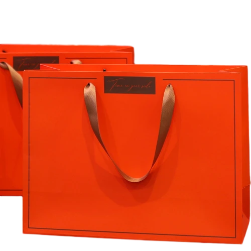 Special Craft Paper Bags adopt vibrant bright orange matte surface decorated with thin dark border and delicate label slogan. Matching golden ribbon handles are soft and durable for comfortable hand holding. Thick rigid craft paper keeps the bag upright and maintains great shape. The warm bright tone is ideal for holiday celebration and gift giving. We support custom bag size base color label text and brand logo. These paper bags fit festival gifts anniversary presents retail boutique shopping and luxury gift set packing.