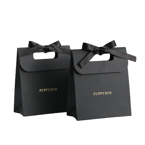 Special Craft Paper Bags adopt premium matte black paper with elegant flip top design and satin bow decoration. Custom gold foil hot stamping logo adds luxury delicate texture. Pre cut handle hole makes carrying convenient. Thick paper material ensures stable structure and good standing effect. Minimalist high end style fits small gifts jewelry cosmetics and premium brand packaging. We support custom bag size printed logo and surface craft. These paper bags are ideal for boutique retail birthday gifts wedding favors and luxury gift sets.