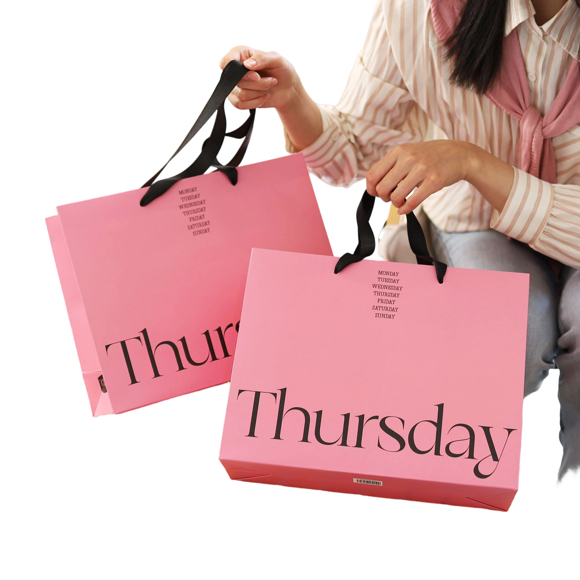 Special Craft Paper Bags feature vibrant hot pink base printed with stylish large Thursday serif letter and compact weekly calendar text on upper area. Matching black wide ribbon handles look contrasting fashionable and ensure comfortable hand holding. Thick premium craft paper keeps the bag rigid and holds tidy shape. Bold color combination and simple typography create trendy modern style for retail store and gift packaging. We support custom bag size base color printed text and brand logo. These paper bags fit fashion boutique shopping cosmetic packaging birthday gifts and holiday gift sets.