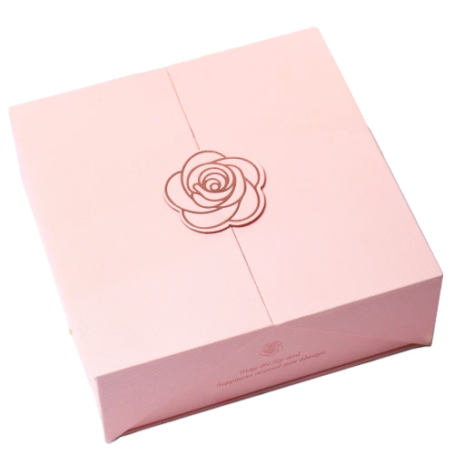 This charming double opening custom rigid magnetic gift box features smooth matte soft pink surface. An exquisite rose shaped ornament is fixed at the middle seam of the two lids to deliver romantic aesthetic feeling. Warm greeting words can be printed along the bottom edge of the box. Built in magnetic parts firmly lock both flaps after closing. Thick sturdy rigid cardboard maintains perfect square box shape. You can customize box color flower decoration style slogan text brand logo and outer dimensions. It fits well for wedding favors skincare gifts birthday surprises bridal shower presents and romantic celebration gift packaging.